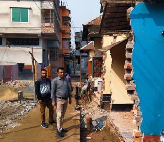 রাস্তা নির্মাণে বাড়ির বর্ধিত অংশ ভেঙে দিচ্ছেন মালিকরাই